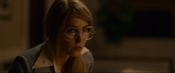 Movie still from “Stockholm” (2018), directed by Robert Budreau – A woman wearing glasses looking at the camera; Close Up shot, Over the shoulder angle