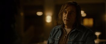 Movie still from “Stockholm” (2018), directed by Robert Budreau – A man in a denim jacket looking at the camera; Close Up shot, Over the shoulder angle