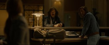 Movie still from “Stockholm” (2018), directed by Robert Budreau – A man sitting at a desk in a dark room; Medium shot, Over the shoulder angle