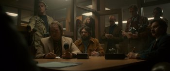 Movie still from “Stockholm” (2018), directed by Robert Budreau – A group of people sitting around a table; Medium shot, Low angle