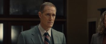 Movie still from “Stockholm” (2018), directed by Robert Budreau – A man in a suit and a tie; Close Up shot, Over the shoulder angle