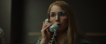 Movie still from “Stockholm” (2018), directed by Robert Budreau – A woman with glasses talking on a phone; Close Up shot, Low angle