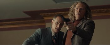 Movie still from “Stockholm” (2018), directed by Robert Budreau – A man and a woman holding a cell phone in their hands; Medium shot, Low angle