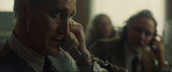 Movie still from “Stockholm” (2018), directed by Robert Budreau – A man talking on a phone while sitting in a chair; Close Up shot, Over the shoulder angle