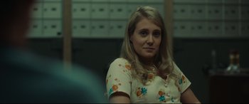 Movie still from “Stockholm” (2018), directed by Robert Budreau – A woman with blonde hair wearing a floral shirt; Close Up shot, Over the shoulder angle