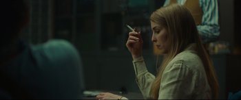 Movie still from “Stockholm” (2018), directed by Robert Budreau – A woman smoking a cigarette while sitting at a table; Close Up shot, Over the shoulder angle
