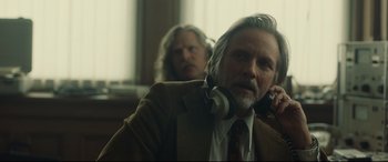 Movie still from “Stockholm” (2018), directed by Robert Budreau – A man in a suit and tie talking on a phone; Close Up shot, Over the shoulder angle
