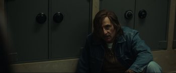 Movie still from “Stockholm” (2018), directed by Robert Budreau – A man sitting on a train looking sad; Medium shot, Over the shoulder angle