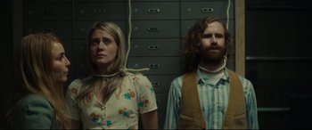 Movie still from “Stockholm” (2018), directed by Robert Budreau – A man and a woman standing next to each other; Medium shot, Low angle