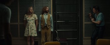 Movie still from “Stockholm” (2018), directed by Robert Budreau – A man and a woman standing next to each other in a room; Wide shot, Low angle