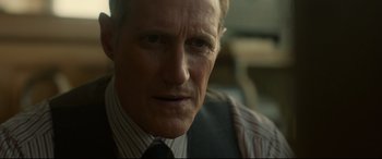 Movie still from “Stockholm” (2018), directed by Robert Budreau – A person wearing a suit and tie; Close Up shot, Over the shoulder angle