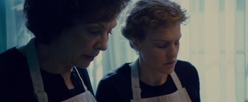 Movie still from “Stoker” (2013), directed by Park Chan-wook – Two women wearing aprons looking at each other; Close Up shot, Low angle