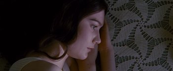 Movie still from “Stoker” (2013), directed by Park Chan-wook – A woman sitting on the ground with her head resting on her hand; Close Up shot, Overhead angle