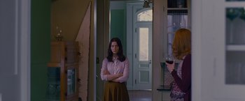 Movie still from “Stoker” (2013), directed by Park Chan-wook – A woman standing in front of an open door with her arms crossed; Medium shot, Over the shoulder angle