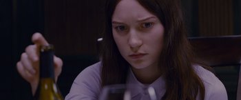 Movie still from “Stoker” (2013), directed by Park Chan-wook – A woman sitting in front of a wine glass; Close Up shot, High angle
