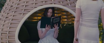 Movie still from “Stoker” (2013), directed by Park Chan-wook – A woman sitting on a chair reading a book; Medium shot, Low angle