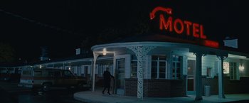 Movie still from “Stoker” (2013), directed by Park Chan-wook – A person walking in front of a restaurant at night; Wide shot, Low angle