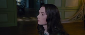 Movie still from “Stoker” (2013), directed by Park Chan-wook – A woman with long dark brown hair looking to her left; Close Up shot, Over the shoulder angle