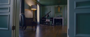 Movie still from “Stoker” (2013), directed by Park Chan-wook – A woman sitting in front of a grand piano in a living room; Wide shot, High angle