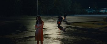 Movie still from “Stoker” (2013), directed by Park Chan-wook – A woman standing in the middle of the street at night; Wide shot, Over the shoulder angle