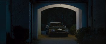 Movie still from “Stoker” (2013), directed by Park Chan-wook – A car parked in a driveway at night under an arched garage door; Wide shot, Low angle