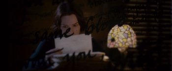 Movie still from “Stoker” (2013), directed by Park Chan-wook – A woman looking at a piece of paper in front of a mirror; Close Up shot, Over the shoulder angle