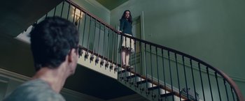 Movie still from “Stoker” (2013), directed by Park Chan-wook – A woman standing on a staircase in front of a door; Wide shot, Low angle