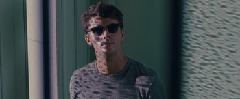 Movie still from “Stoker” (2013), directed by Park Chan-wook – A man wearing sunglasses and a gray shirt; Close Up shot, Over the shoulder angle