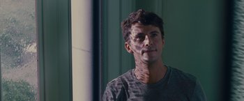 Movie still from “Stoker” (2013), directed by Park Chan-wook – A young man is standing in front of a pillar; Close Up shot, Over the shoulder angle