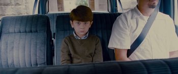 Movie still from “Stoker” (2013), directed by Park Chan-wook – A boy sitting in the back seat of a car; Medium shot, Over the shoulder angle
