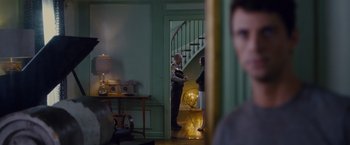 Movie still from “Stoker” (2013), directed by Park Chan-wook – Two men standing in front of each other in front of a staircase; Wide shot, Over the shoulder angle