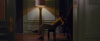 Movie still from “Stoker” (2013), directed by Park Chan-wook – A man sitting on a chair in a room; Wide shot, Low angle