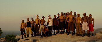 A group of men standing on top of a sandy hill