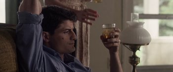 Movie still from “Stone” (2010), directed by John Curran – A man sitting in front of a woman holding a glass of beer; Close Up shot, Over the shoulder angle