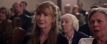 Movie still from “Stone” (2010), directed by John Curran – Two women standing next to each other in front of a crowd; Close Up shot, Over the shoulder angle