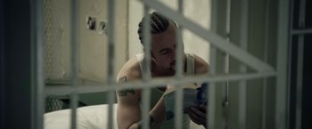 Movie still from “Stone” (2010), directed by John Curran – A man sitting in front of a cell phone; Close Up shot, Over the shoulder angle