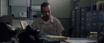 Movie still from “Stone” (2010), directed by John Curran – A man sitting at a table in front of a phone; Close Up shot, Over the shoulder angle