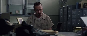 Movie still from “Stone” (2010), directed by John Curran – A man sitting at a table in front of a phone; Close Up shot, Over the shoulder angle