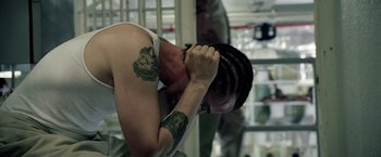 Movie still from “Stone” (2010), directed by John Curran – A man with tattoos on his arms and head; Close Up shot, High angle