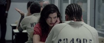 Movie still from “Stone” (2010), directed by John Curran – A woman sitting in front of a group of people; Close Up shot, Over the shoulder angle