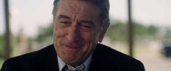 Movie still from “Stone” (2010), directed by John Curran – An older man wearing a suit and tie; Close Up shot, Over the shoulder angle