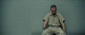 Movie still from “Stone” (2010), directed by John Curran – A man sitting on a bench in a jail cell; Close Up shot, High angle