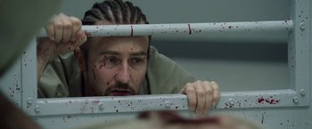 Movie still from “Stone” (2010), directed by John Curran – A man in a jail cell with blood on his face; Close Up shot, Low angle