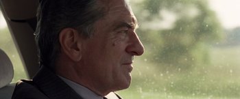 Movie still from “Stone” (2010), directed by John Curran – An older man in a suit looking out of a window; Close Up shot, Over the shoulder angle