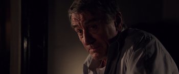 Movie still from “Stone” (2010), directed by John Curran – An older man looking at the camera; Close Up shot, Over the shoulder angle