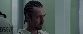 Movie still from “Stone” (2010), directed by John Curran – A man with long hair is looking to his left; Close Up shot, Low angle