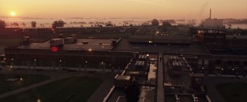Movie still from “Stone” (2010), directed by John Curran – A person sitting on the top of a building at night; Extreme Wide shot, Low angle