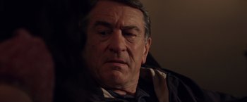 Movie still from “Stone” (2010), directed by John Curran – An older man is looking at the camera; Close Up shot, Over the shoulder angle