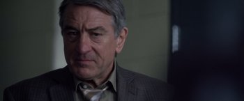 Movie still from “Stone” (2010), directed by John Curran – An older man wearing a suit and a tie; Close Up shot, Over the shoulder angle