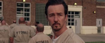 Movie still from “Stone” (2010), directed by John Curran – A person wearing a prison uniform; Close Up shot, Over the shoulder angle